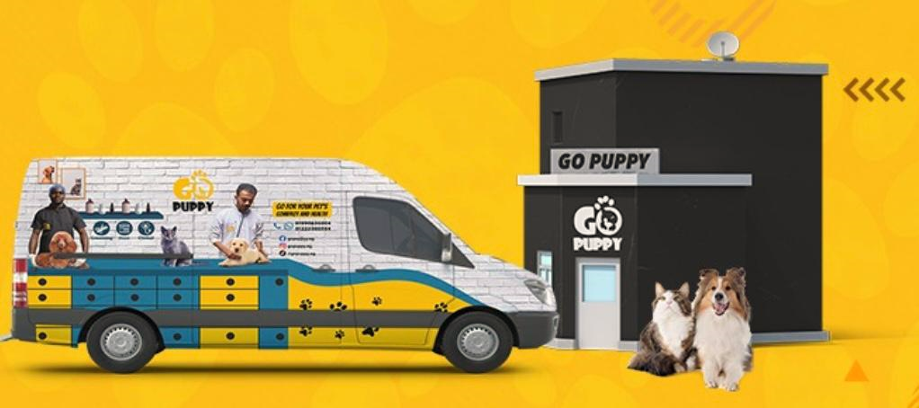 The GoPuppy grooming van parked beside the GoPuppy store, with a cat and a dog in front